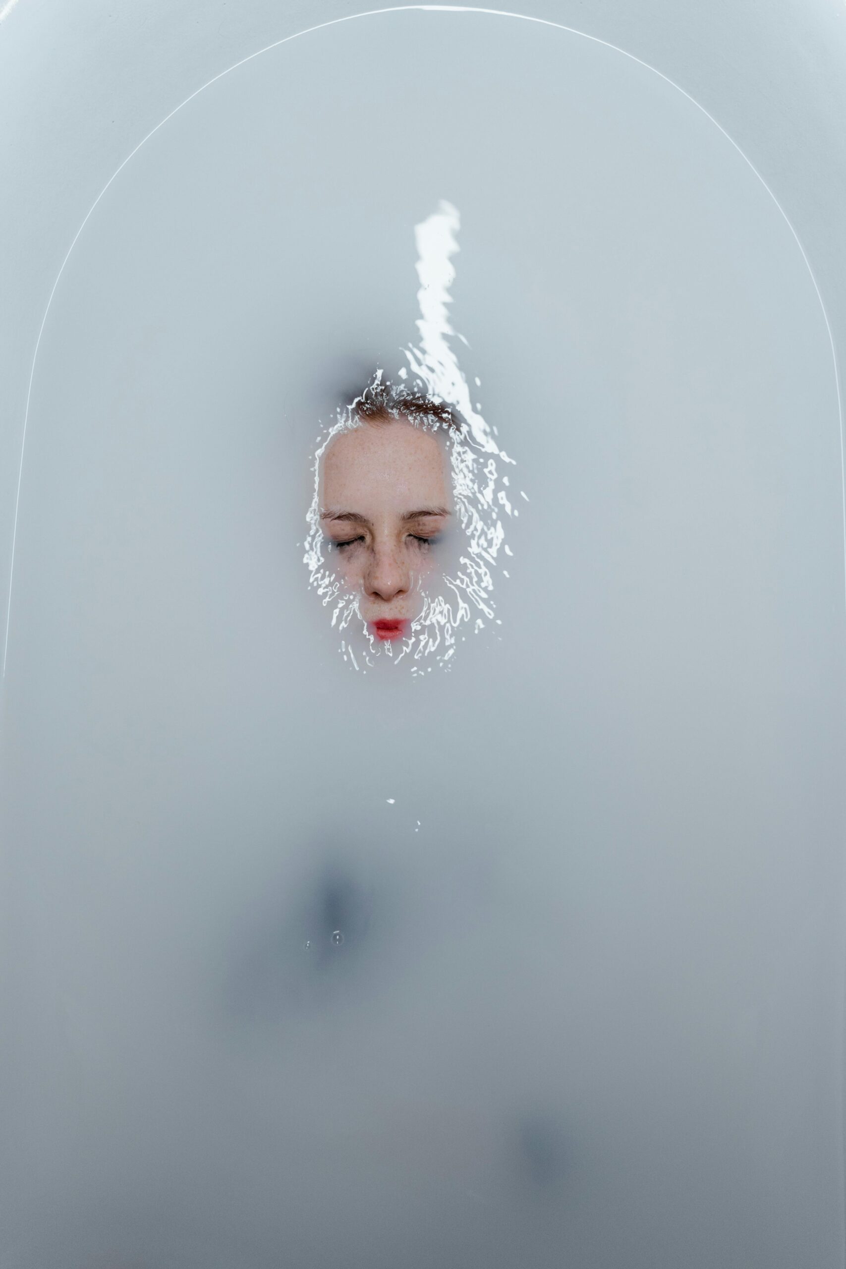 A serene moment of solitude with a woman underwater in a bathtub, evoking emotion.