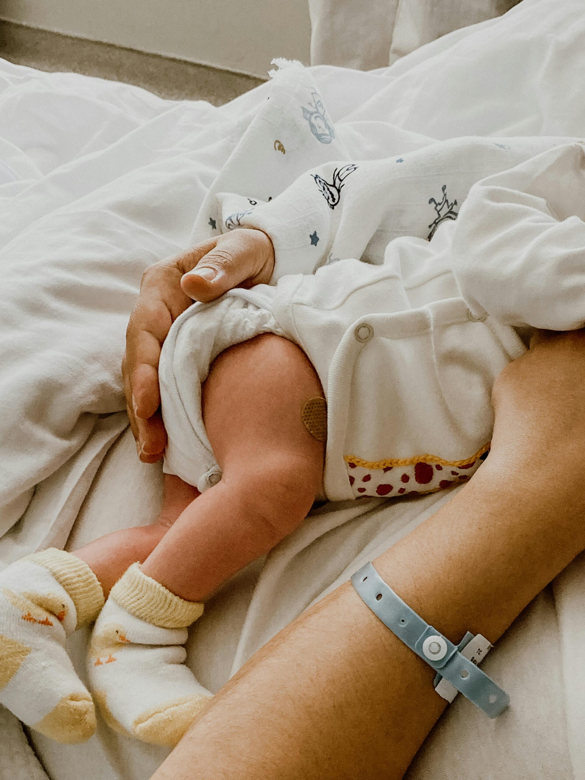 Tender moment captured between mother and newborn baby in a hospital setting.