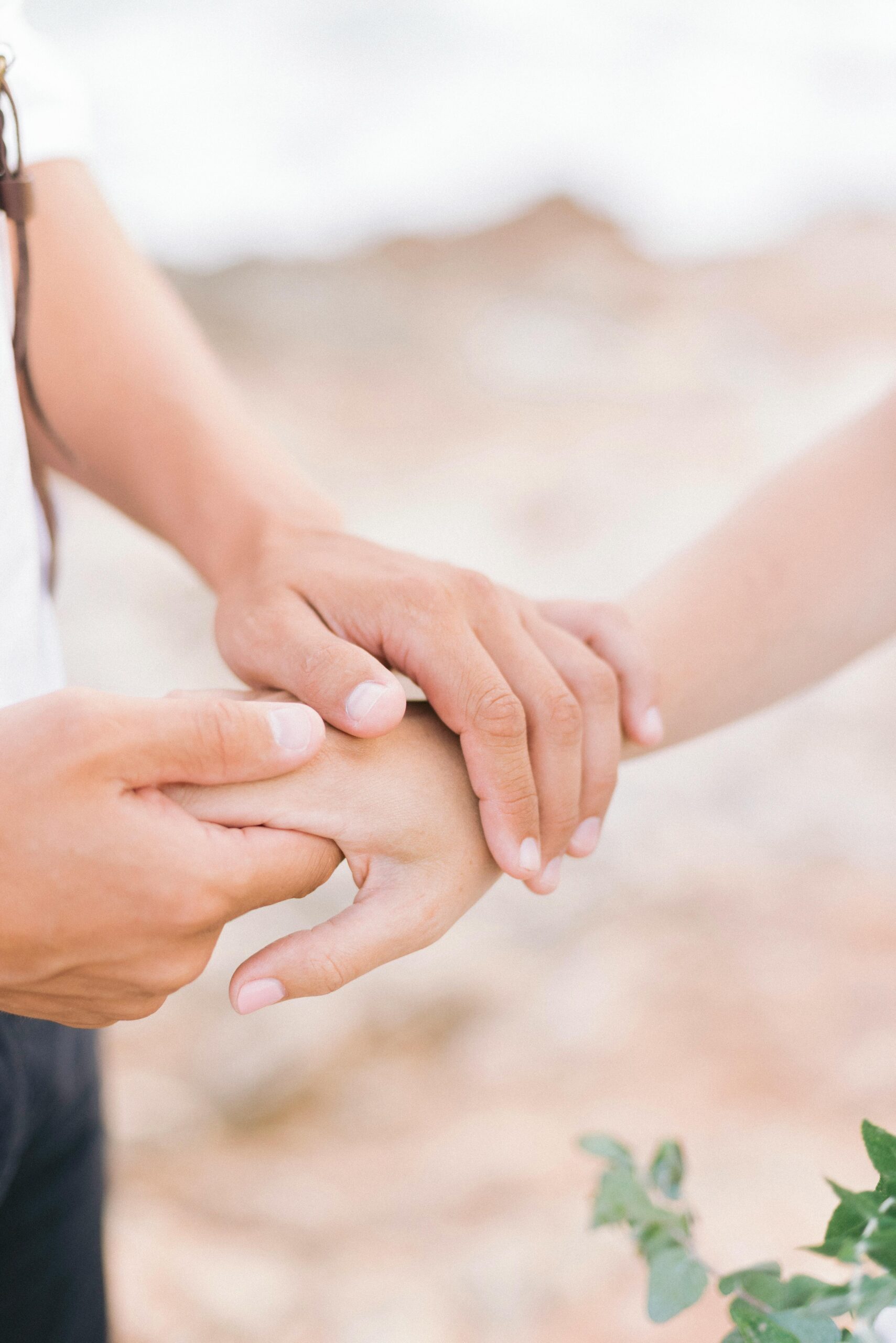 A touching moment captured in nature, depicting hands holding gently, conveying connection.