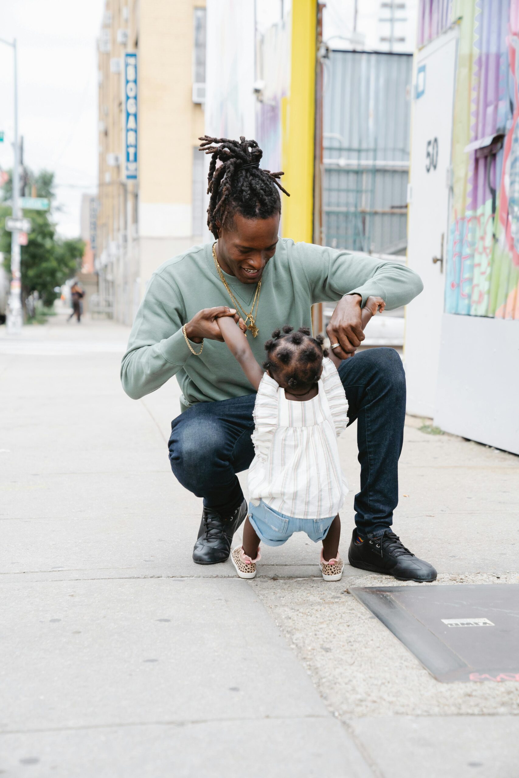 Father and daughter enjoying bonding time on a vibrant city street, capturing joyful moments together.